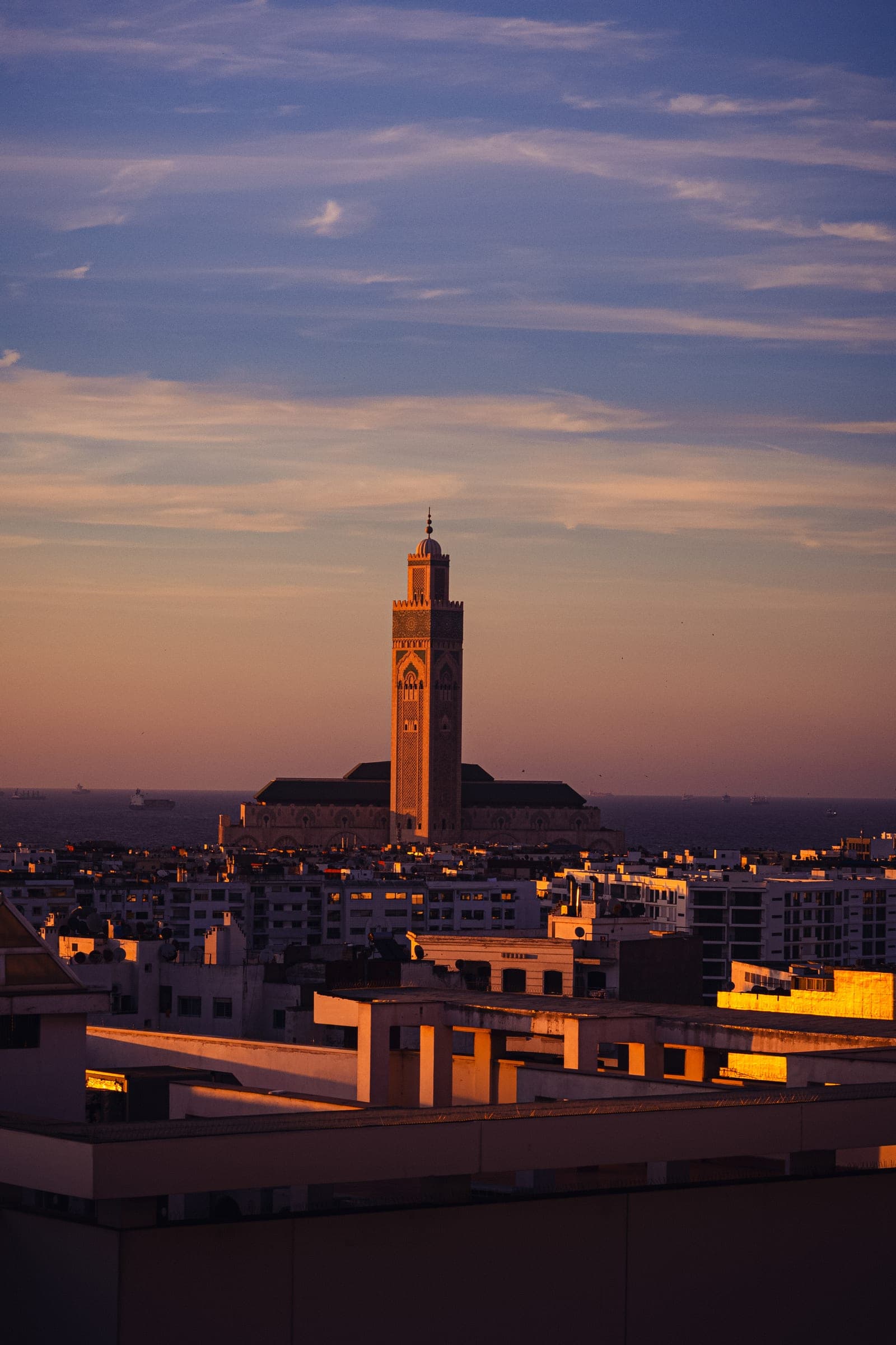 The minaret of the Hassan II Mosque above Casablanca at dusk, the sky pink and blue